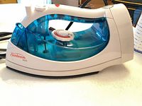 Side profile showing Sunbeam logo, model marking, blue reservoir, and overall body