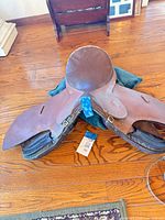 Full view of brown English saddle showing seat, flaps, wear