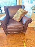 Front view of wingback leather chair with pillow