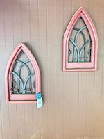 Pair of arched wall hangings mounted on wall