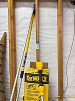 DeWALT trimmer shaft and motor housing leaning beside original yellow DeWALT 20V MAX box