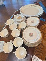 Group view of platter, stacked plates, cups, gravy boat