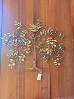 Full view of metal tree wall sculpture on wood background