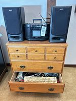 Full lot showing dresser, boombox, speakers, open drawer with keyboard and cables
