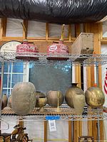 Overall view of seven brass/bronze decorative pieces on shelf