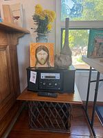 Teac CD stereo, remote, icon tile, two vases, flowers, side table visible