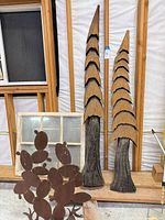 Full lot showing two cone tree sculptures, metal cactus silhouette, multi-pane window frame