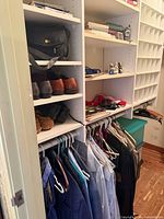 Closet shelves with camera bag, leather shoes, hanging suits, shirts