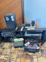 Entire lot on entertainment stand with receiver, speakers, VCR/DVD, printers, cables