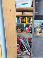 Cabinet full view showing wood finishes, aerosols, holiday wrap and tools