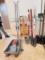 Lot overview showing skis, poles, boots, sleds
