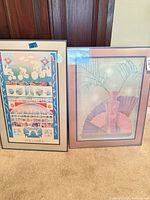 Both framed prints standing side by side on floor