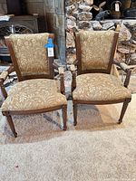 front view of both matching armchairs showing overall style, upholstery and wood frame