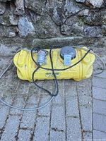 Full view of yellow sprayer tank with pump and hoses