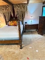 Full view of assembled queen four-poster bed showing headboard, footboard, posts and side rails