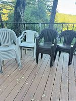 Stacks of light gray and dark brown plastic armchairs on deck