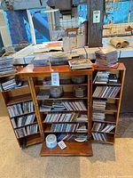 Cabinet open showing shelves filled with CDs and spindle discs