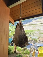 First planter hanging under eave showing slatted construction and strap