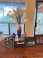 Overview of lot showing magazine rack, tall vase with stems, small vases, frames