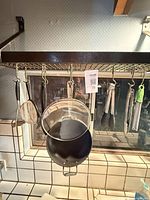 Overall view of pot rack with cookware and utensils