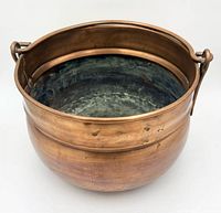 angled view showing copper cauldron exterior and handle