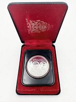 Coin in open presentation case showing obverse design and red interior