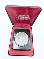 Coin in capsule set in red velvet tray inside presentation case