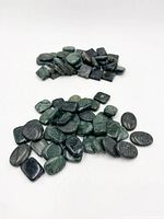 Two piles of assorted flat dark green jade beads