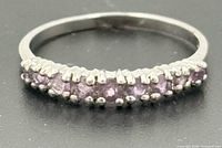 Top view of sterling silver half-eternity ring showing purple stones