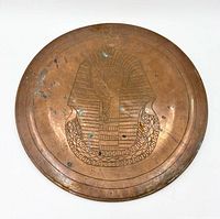 Full view of round copper wall plate showing Tutankhamun engraving
