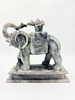 Right side view of carved stone elephant on plinth