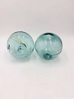 Two aqua glass fishing floats side by side
