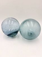 Two aqua glass floats side by side