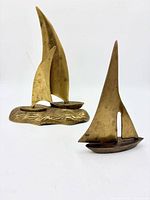 Both brass sailboat sculptures grouped