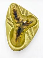 Top view of triangular green ceramic ashtray showing glaze pattern and grooves