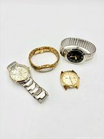 Group shot of four wristwatches displaying overall condition and styles