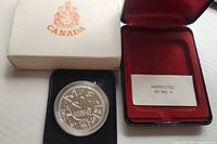 Coin in display case with outer box and inspection card visible