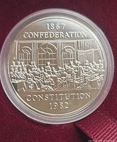 Close-up of 1982 Constitution nickel dollar in capsule, showing reverse design and legends