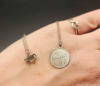 Pendant and ring shown on hand for scale