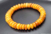 Full view of circular bracelet showing uniform rondelle amber beads