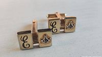 Front view showing both cufflinks with Freemason emblem and letter E faces