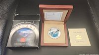 Coin in wooden case with outer box and certificate