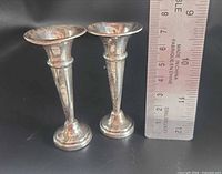 Two silver bud vases beside ruler showing approx. 7 cm height