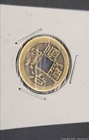 Obverse of brass cash coin showing four Chinese characters