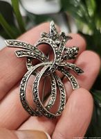 Front of brooch showing ribbon/floral design with marcasite