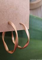 Pair of matte gold twisted hoop earrings mounted on card