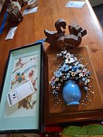 Overview of all items: framed relief plaque, nail art plaque, two carved wood animals