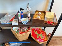 Overview of shelf showing figurines, boxed tea set, basket and textile