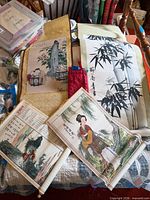 Group of four items displayed: two silk scrolls and two calendars