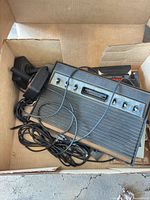 Atari 2600 console with controllers, cables and box visible